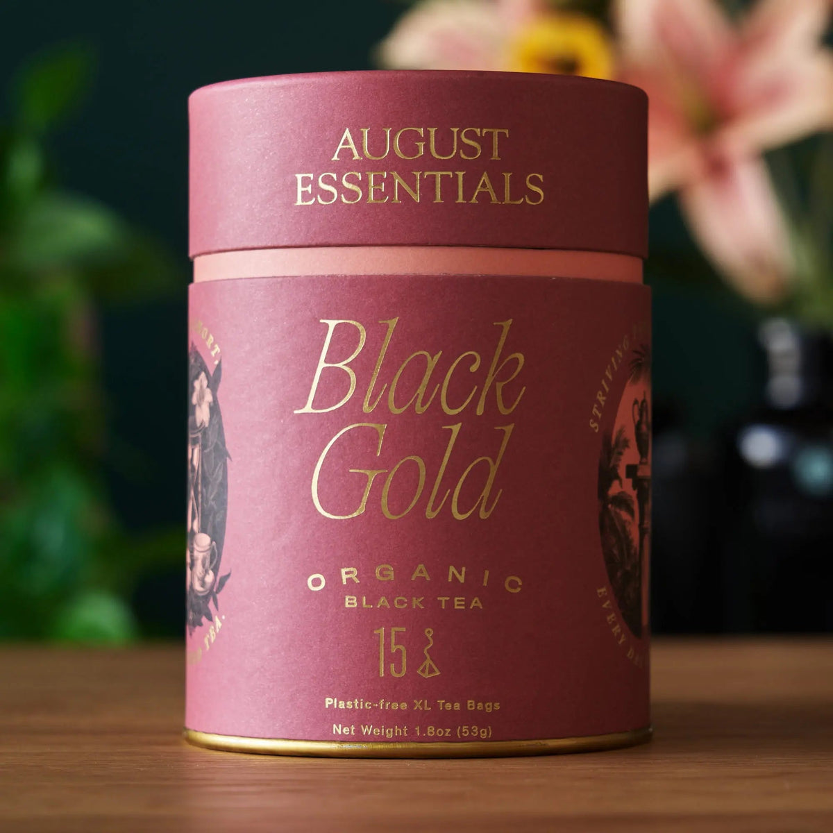 August Essentials Black Gold Organic Yunnan Black Tea in pink and gold cylindrical packaging, 15 tea bags