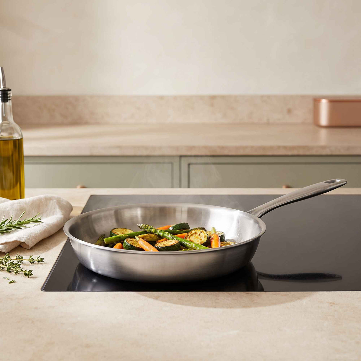 Alva stainless steel frying pan with vegetables cooking on a kitchen stovetop