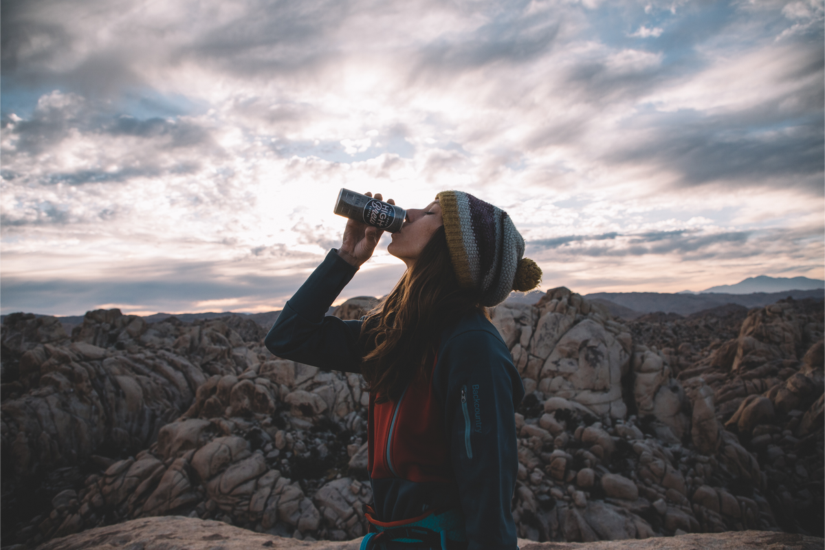 Person enjoying High Brew Black & Bold Cold Brew Coffee outdoors in a mountain landscape