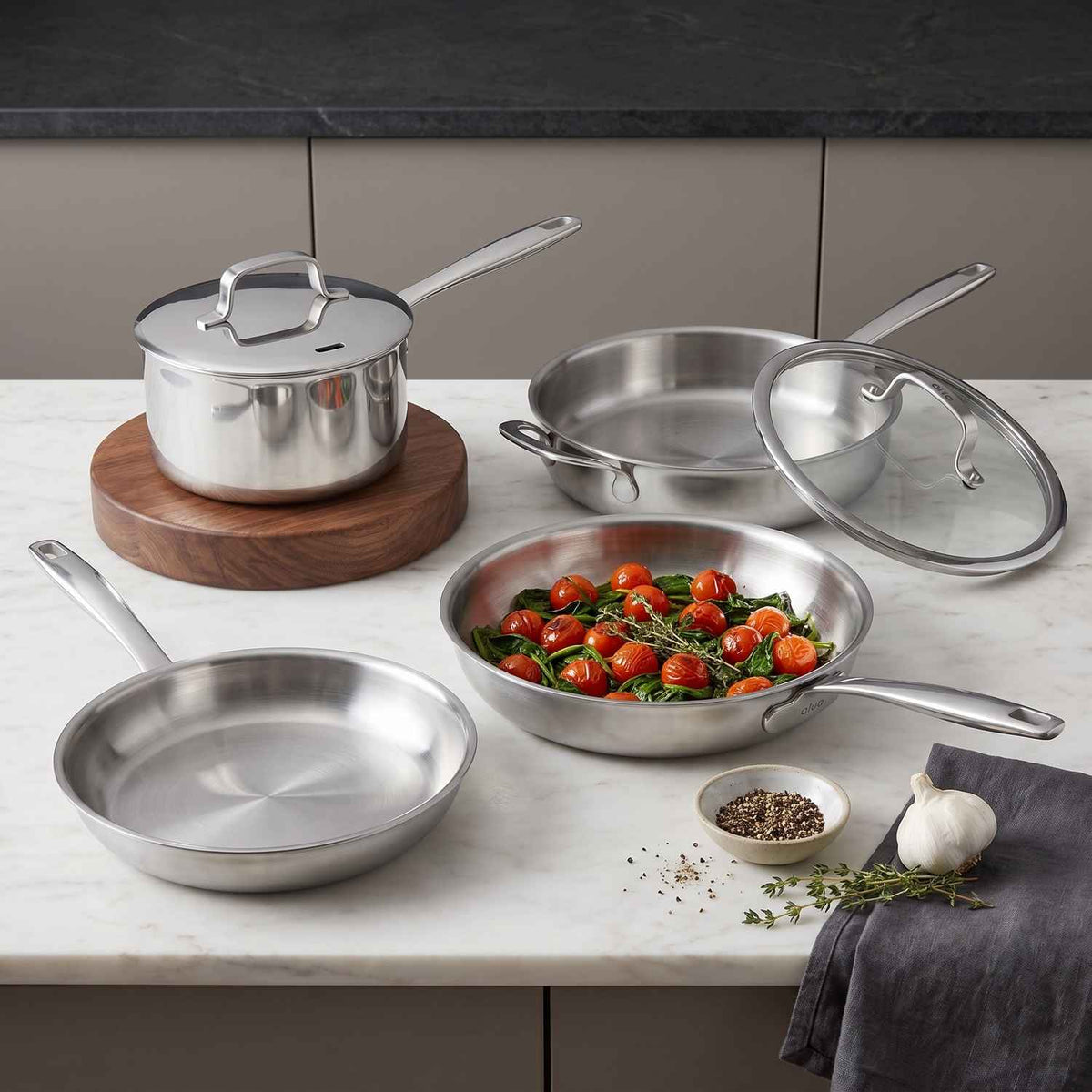 Alva 7-Piece stainless steel cookware collection displayed on a kitchen countertop