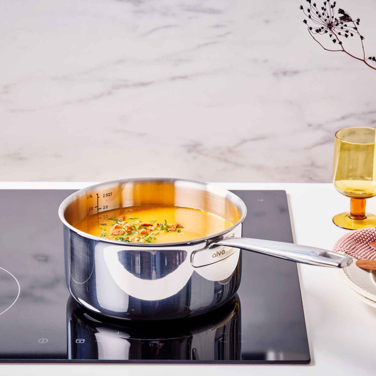 Alva stainless steel saucepan heating a homemade sauce on a kitchen stovetop