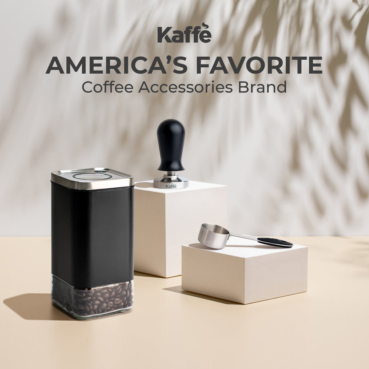 Kaffé black stainless steel coffee storage canister displayed with coffee brewing accessories