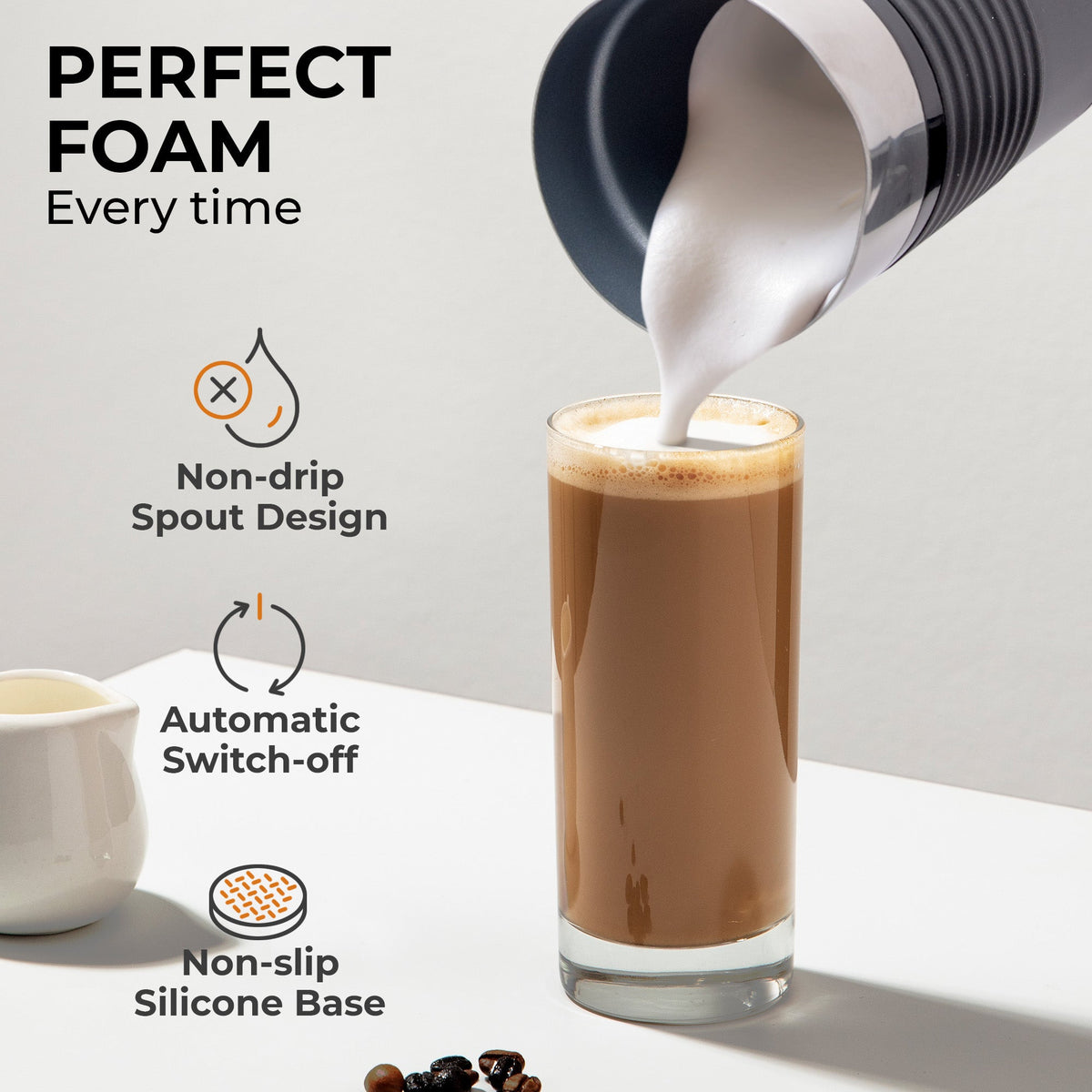 Kaffé electric milk frother pouring creamy foam into a coffee cup