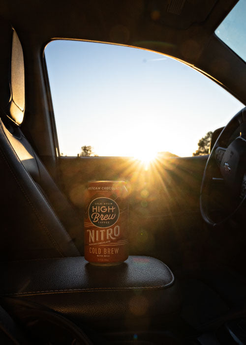 High Brew Nitro Mexican Chocolate Cold Brew Coffee can inside a vehicle with sunlight in the background