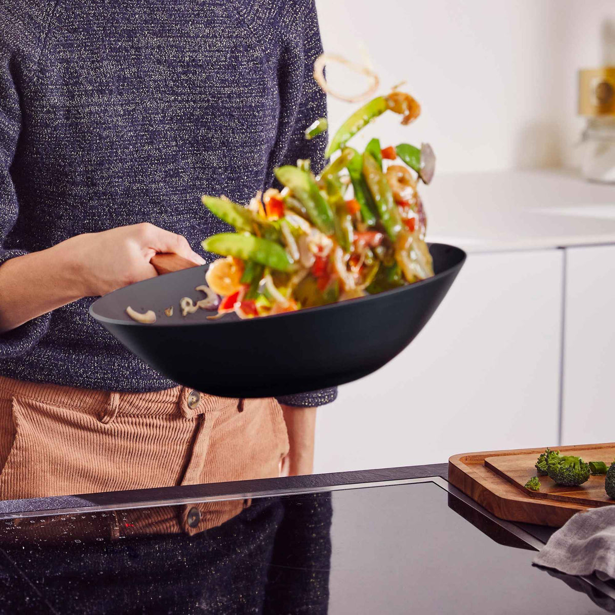 Fresh vegetables being tossed in an Alva carbon steel wok during cooking