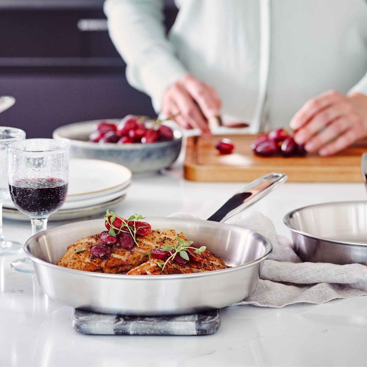 Home cook preparing ingredients beside an Alva stainless steel frying pan