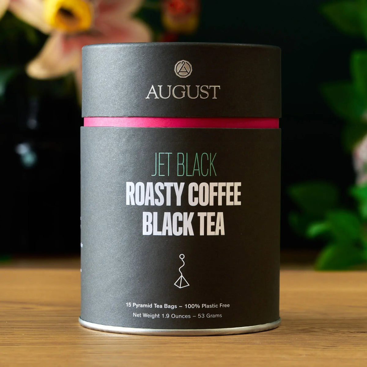 August Jet Black Roasty Coffee Black Tea in black cylindrical tin with pink accent

