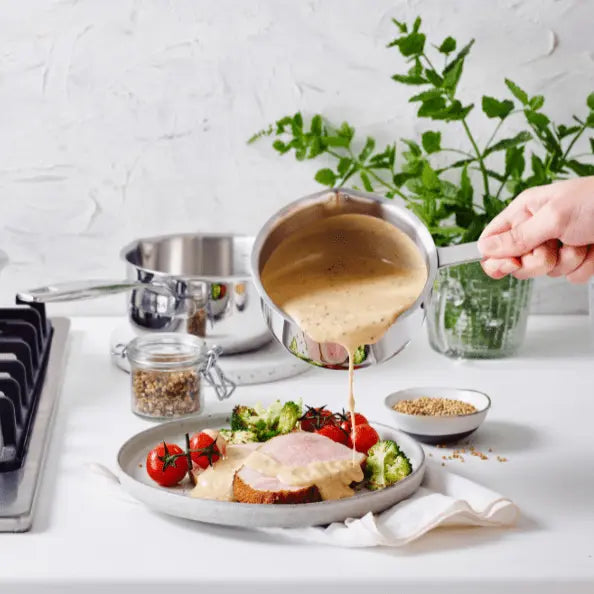 Food being served from Alva stainless steel cookware onto a plate