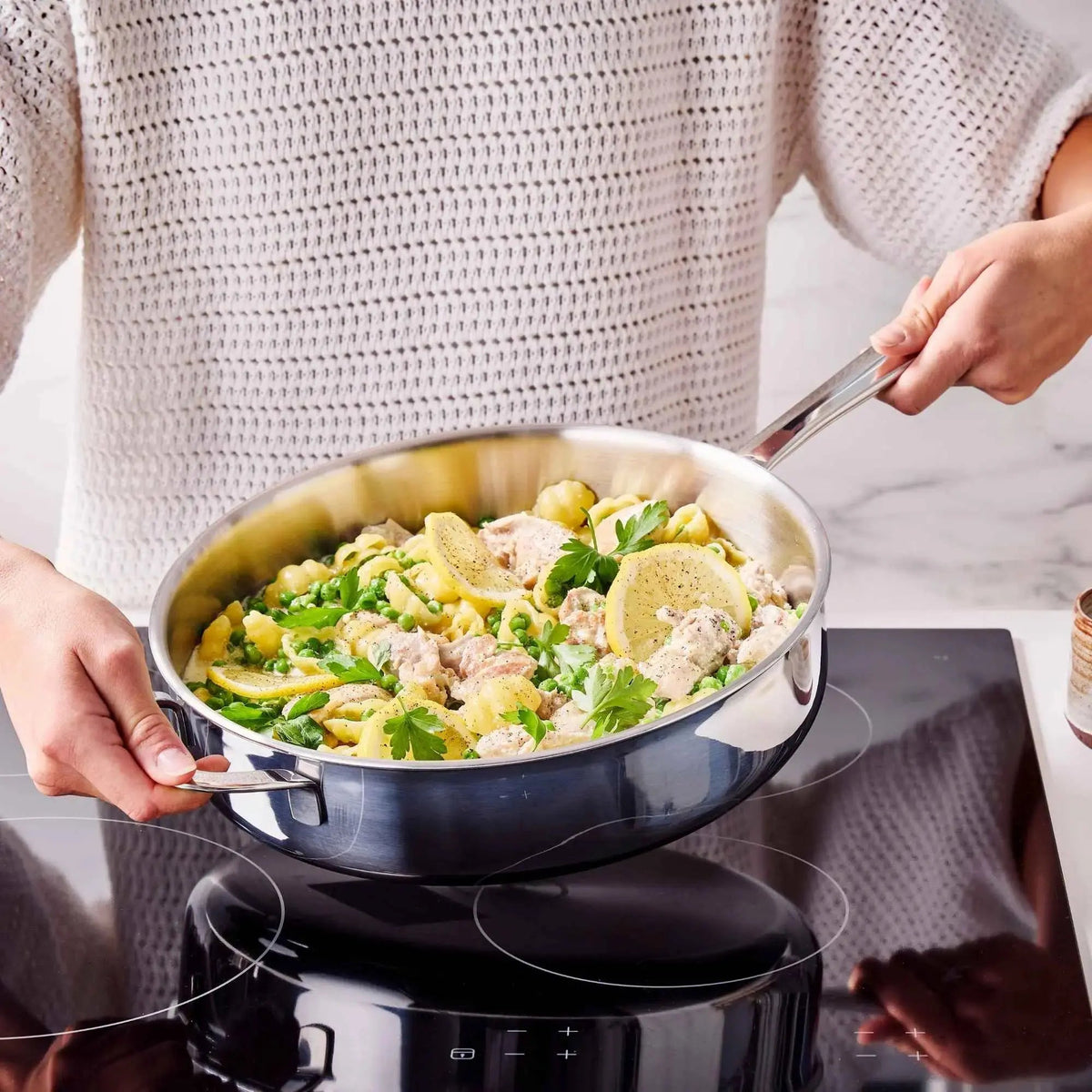 Home cook preparing a vegetable dish in an Alva stainless steel sauté pan